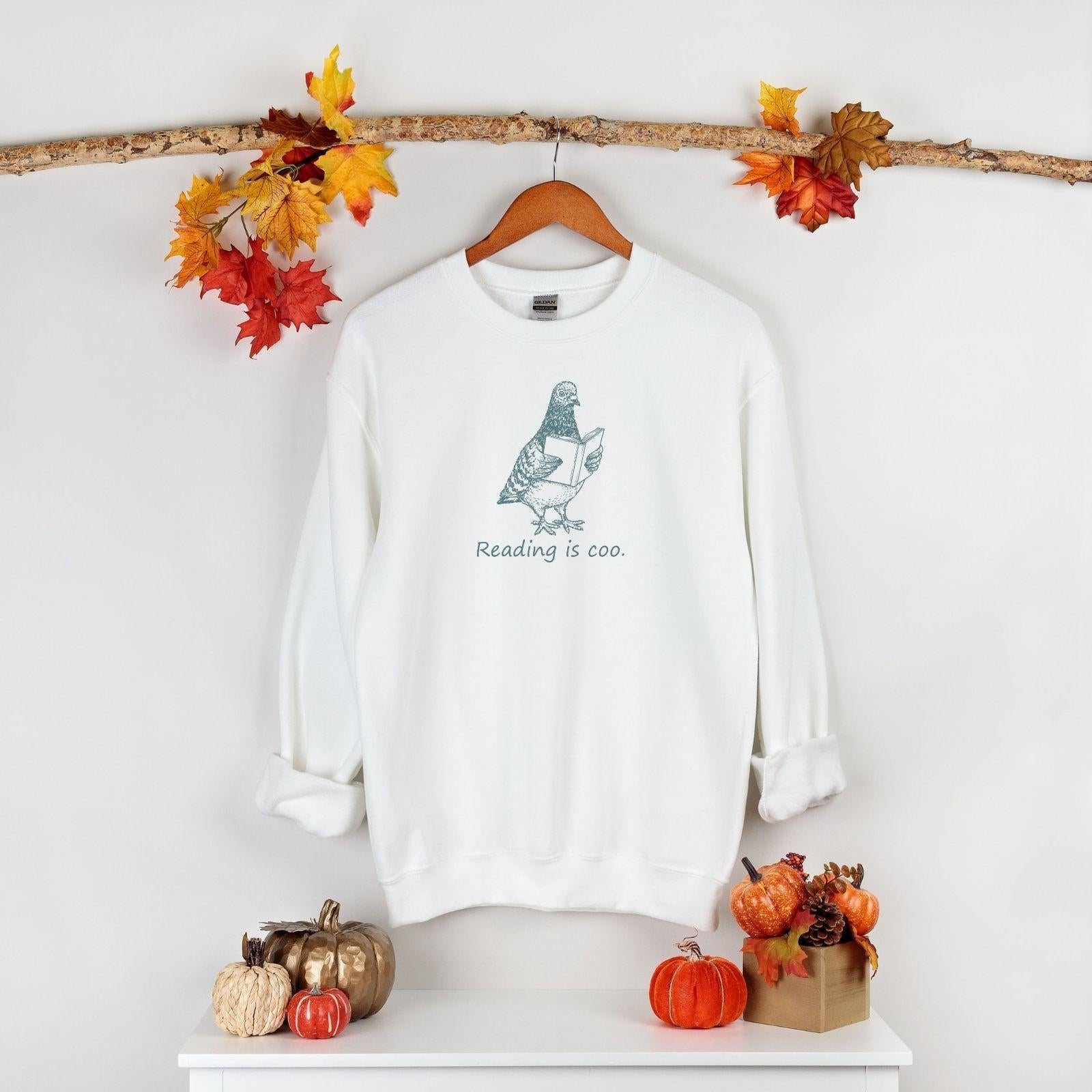 A Gildan 18000 sweatshirt with the saying "reading is coo"