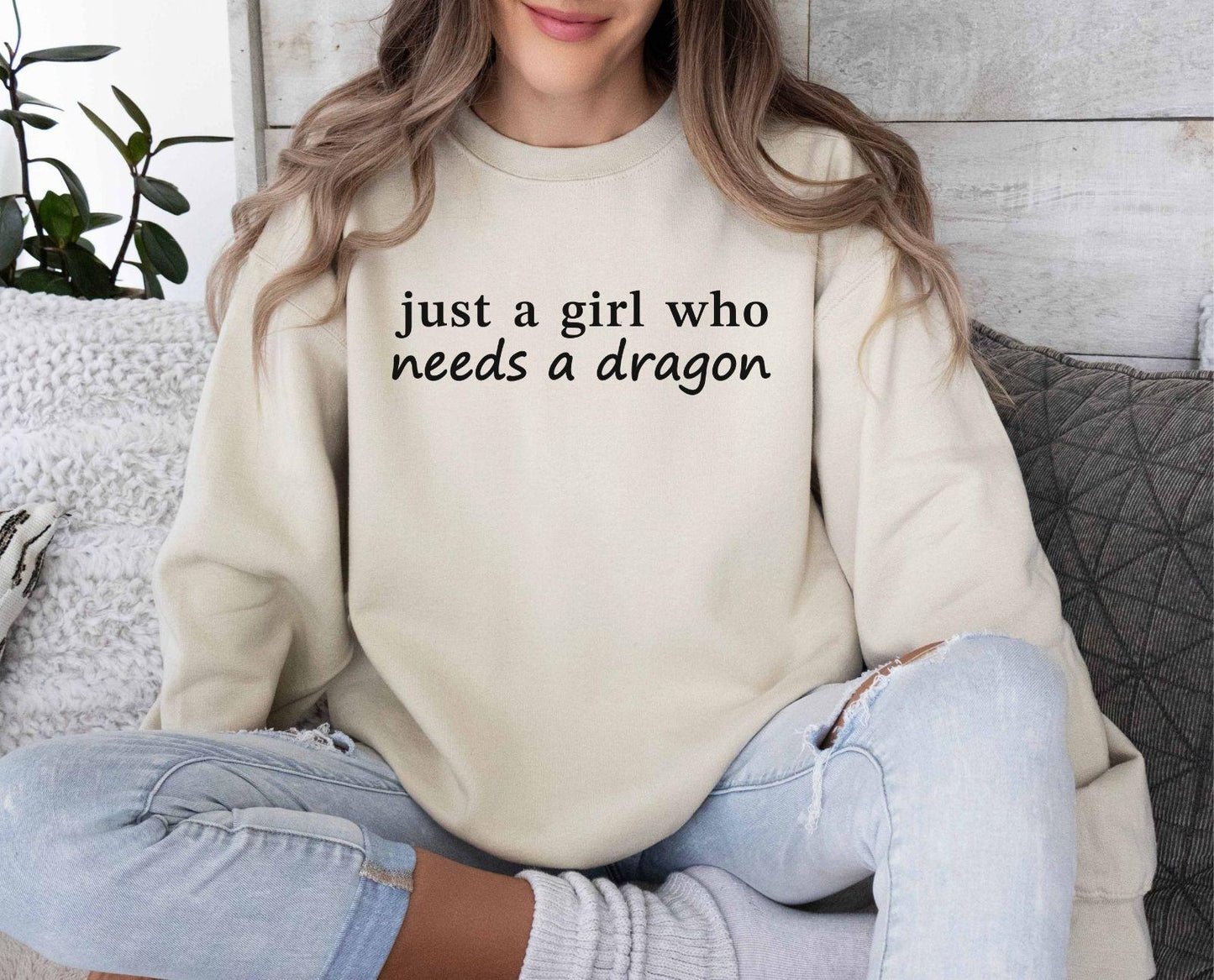 A Gildan 18000 sweatshirt with the saying "just a girl who needs a dragon"