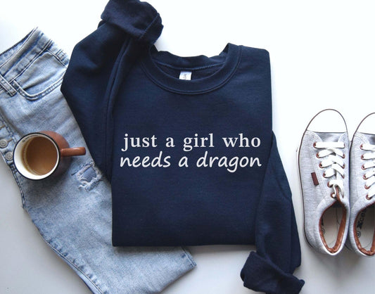 A Gildan 18000 sweatshirt with the saying "just a girl who needs a dragon"