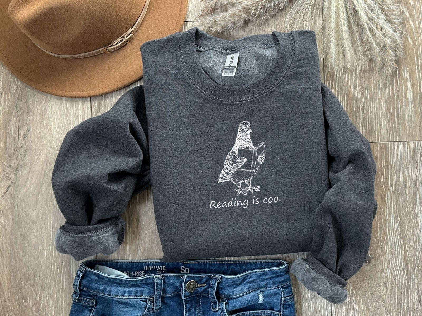 A Gildan 18000 sweatshirt with the saying "reading is coo"