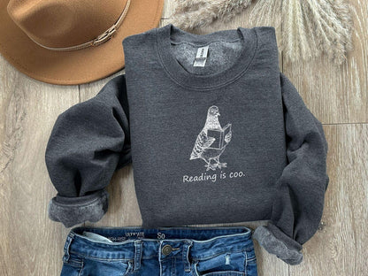 A Gildan 18000 sweatshirt with the saying "reading is coo"