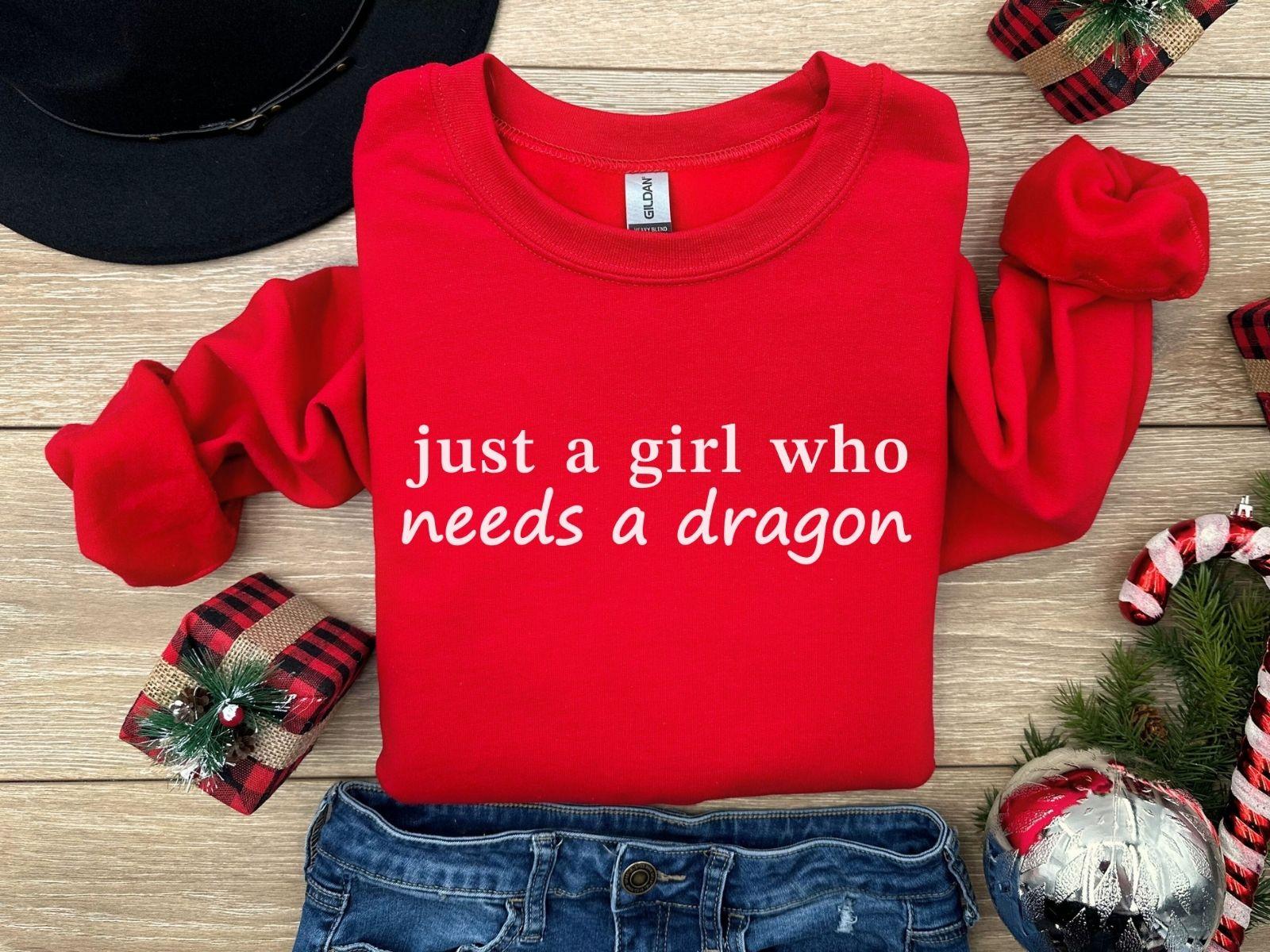 A Gildan 18000 sweatshirt with the saying "just a girl who needs a dragon"