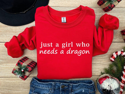 A Gildan 18000 sweatshirt with the saying "just a girl who needs a dragon"
