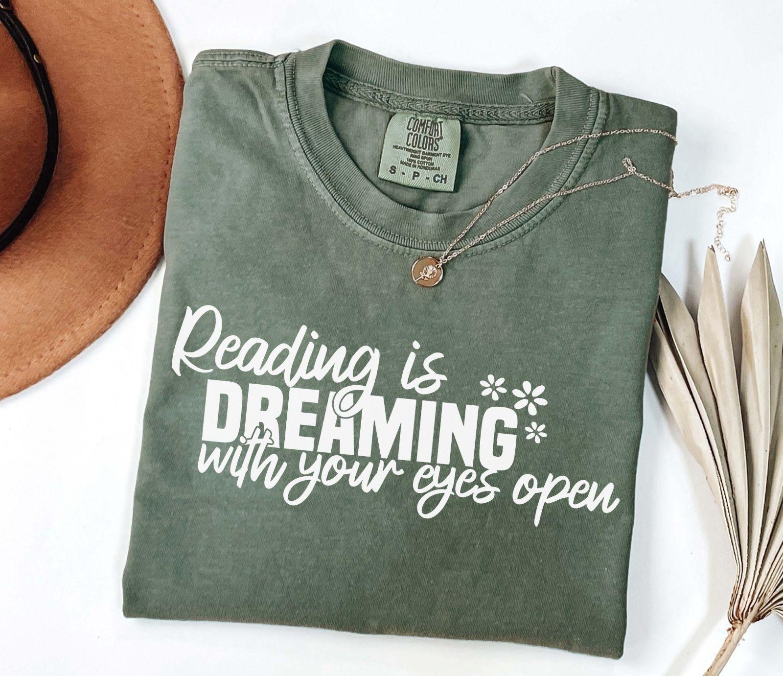 A comfort colors® shirt with the saying "Reading is dreaming with your eyes open"
