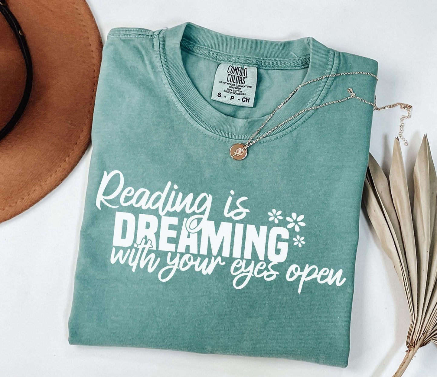 A comfort colors® shirt with the saying "Reading is dreaming with your eyes open"