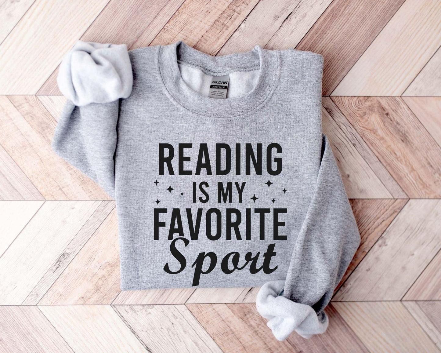 A Gildan 18000 sweatshirt with the saying "Reading is my favorite sport"