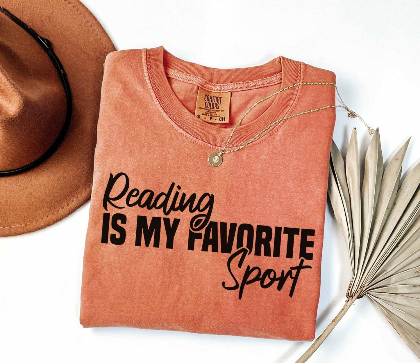 A comfort colors® shirt with the saying "Reading is my favorite sport"