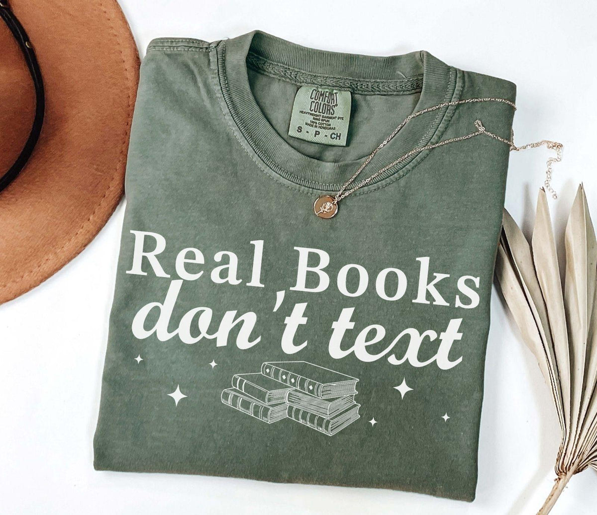 A comfort colors® shirt with the saying "Real books don't text"