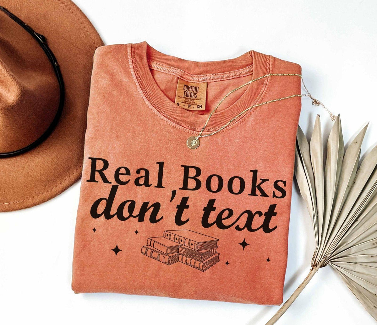 A comfort colors® shirt with the saying "Real books don't text"