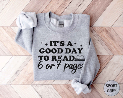 Sport grey sweatshirt with text 'It's a good day to read 6 or 7 pages' on a wooden floor.