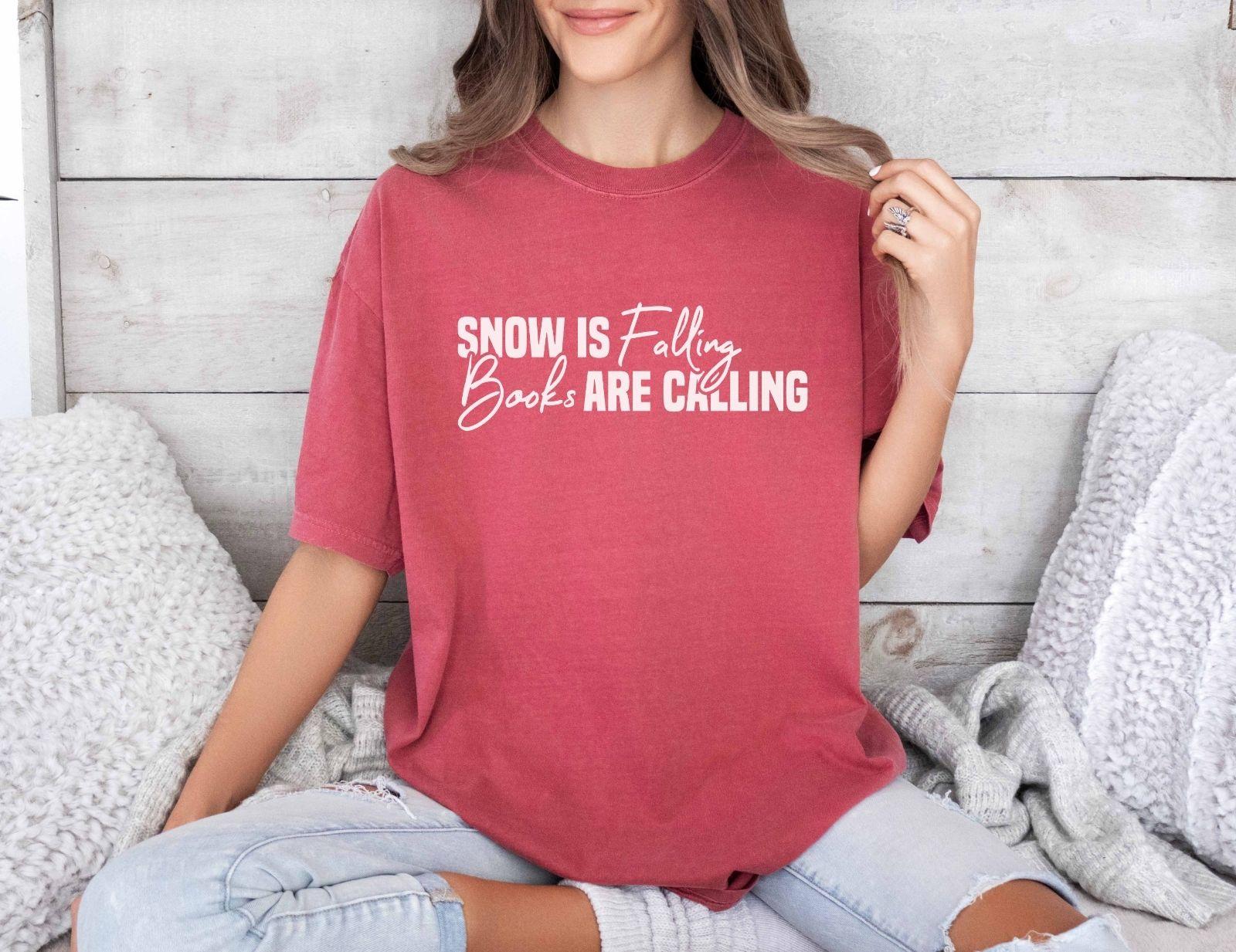 A comfort colors® shirt with the saying "Snow is falling books are calling"