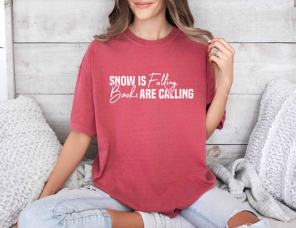A comfort colors® shirt with the saying "Snow is falling books are calling"