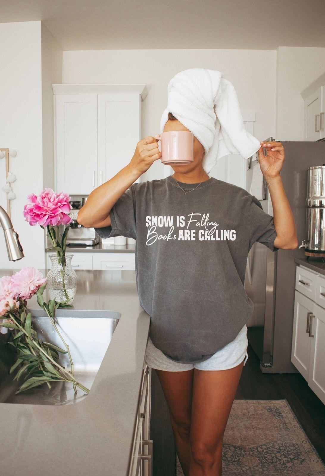 A comfort colors® shirt with the saying "Snow is falling books are calling"