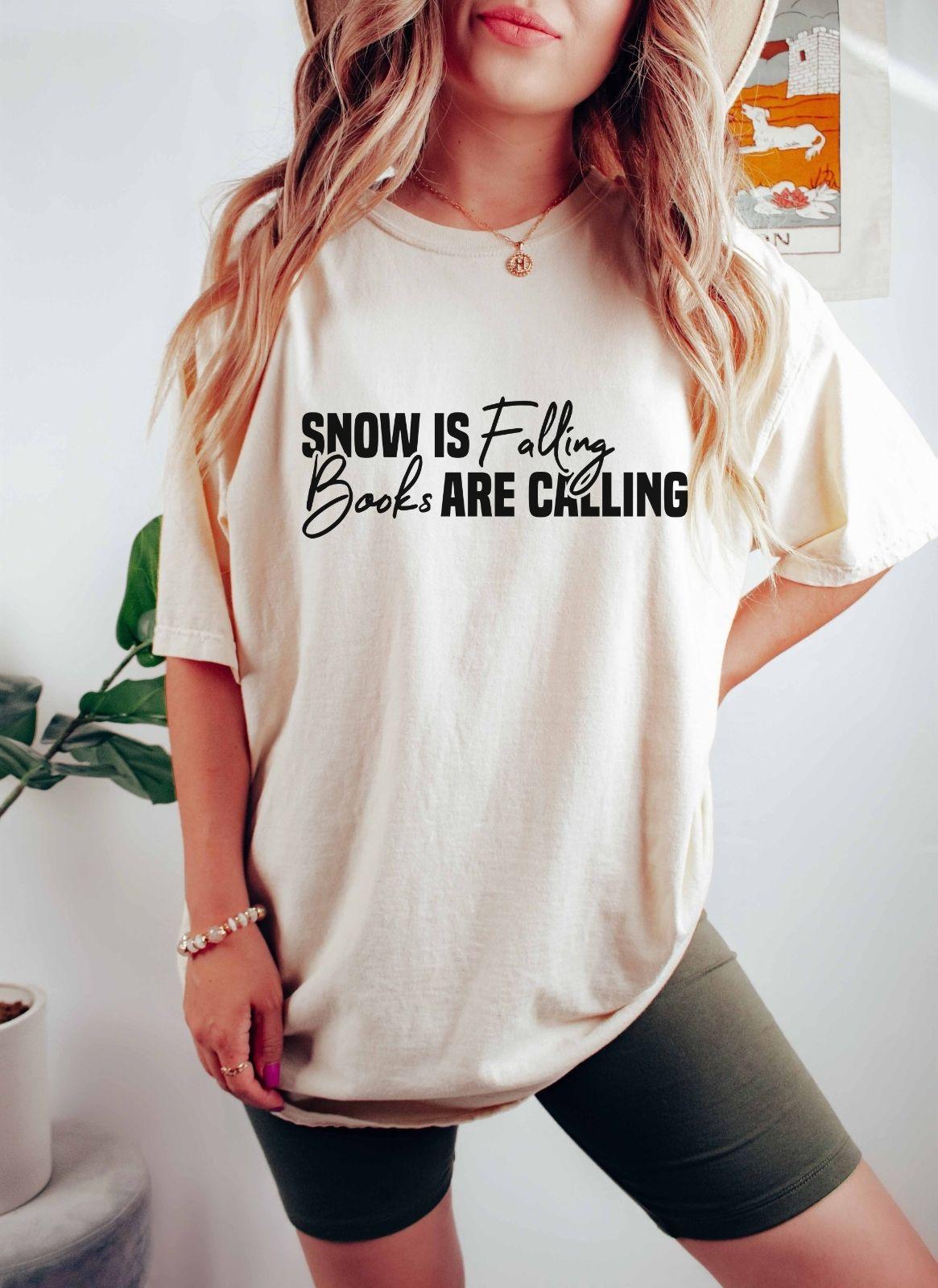 A comfort colors® shirt with the saying "Snow is falling books are calling"