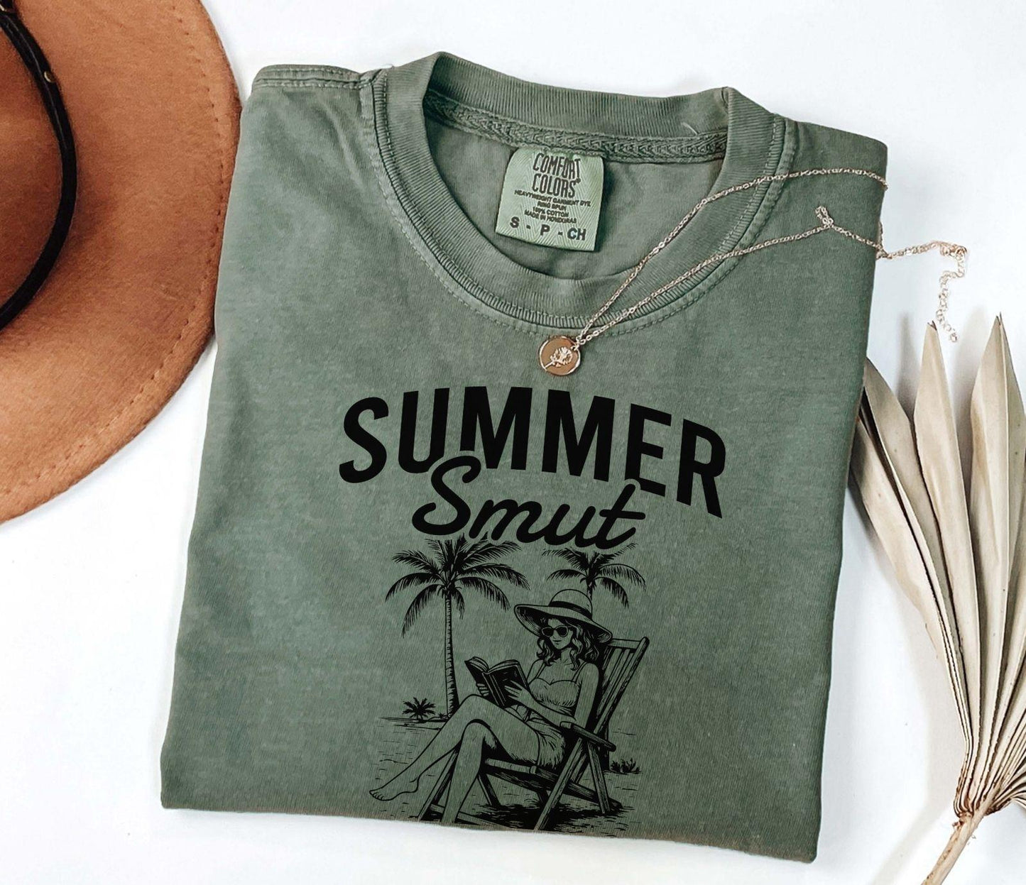 A comfort colors shirt with the saying "Summer smut kissed by the sun"