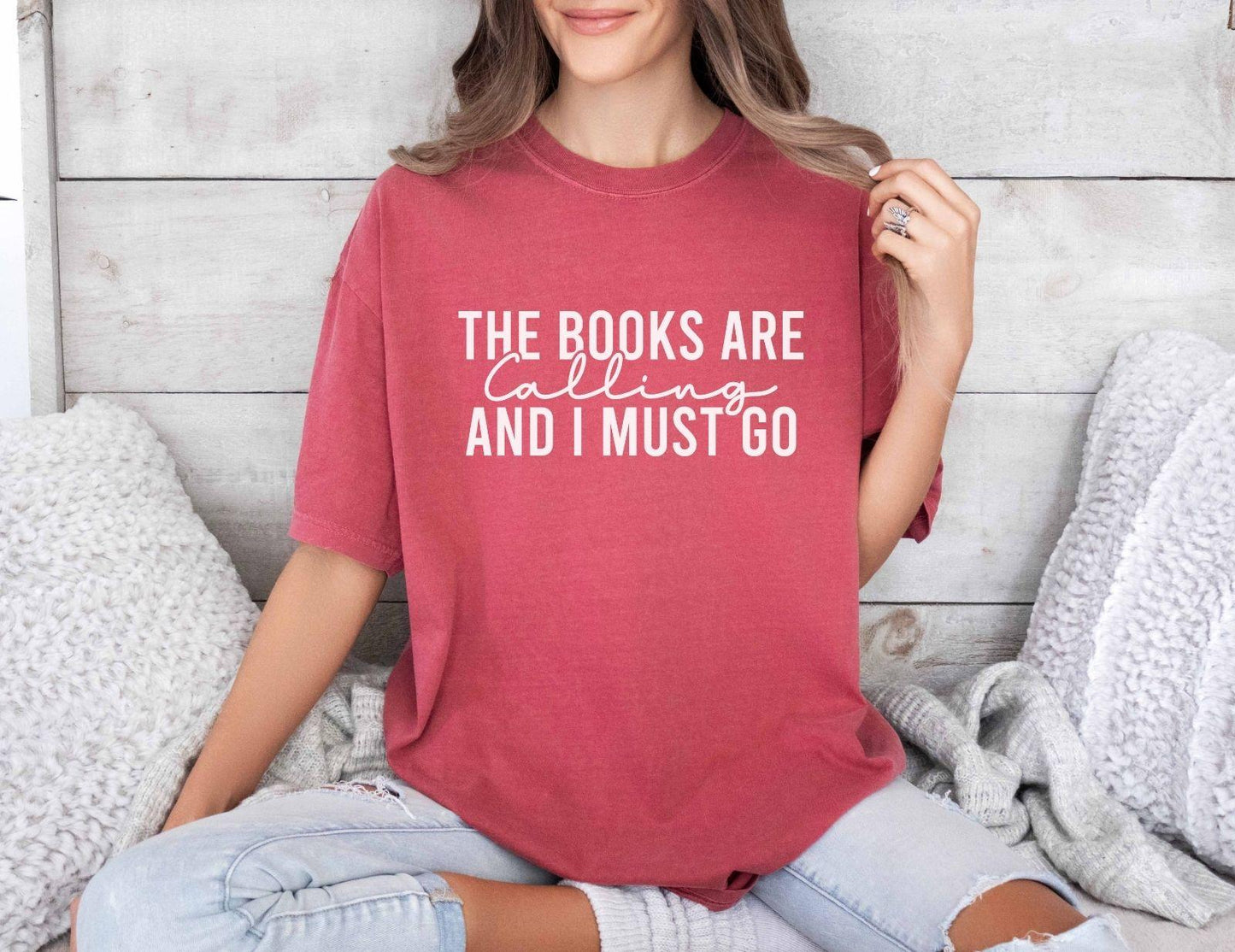 A comfort colors shirt with the saying "the books are calling and I must go"