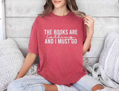 A comfort colors shirt with the saying "the books are calling and I must go"