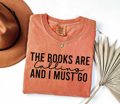 A comfort colors shirt with the saying "the books are calling and I must go"