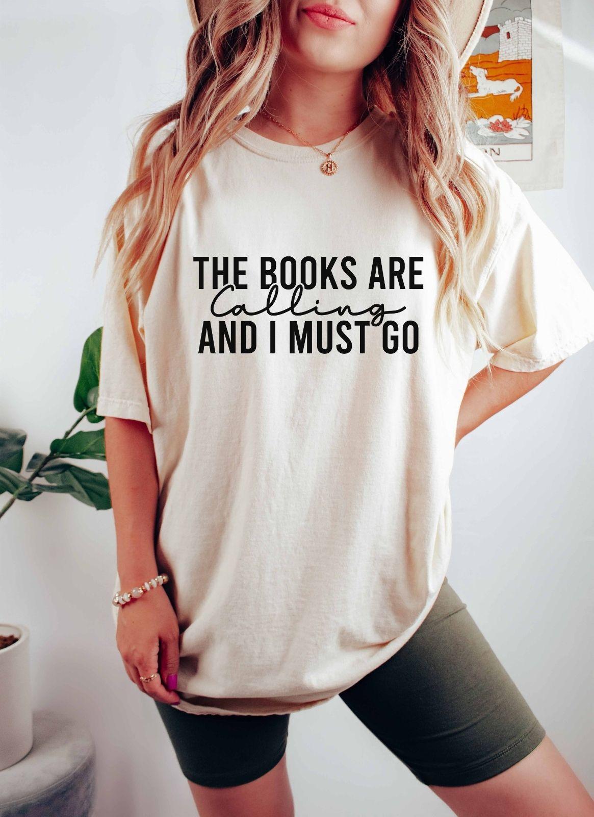 A comfort colors shirt with the saying "the books are calling and I must go"