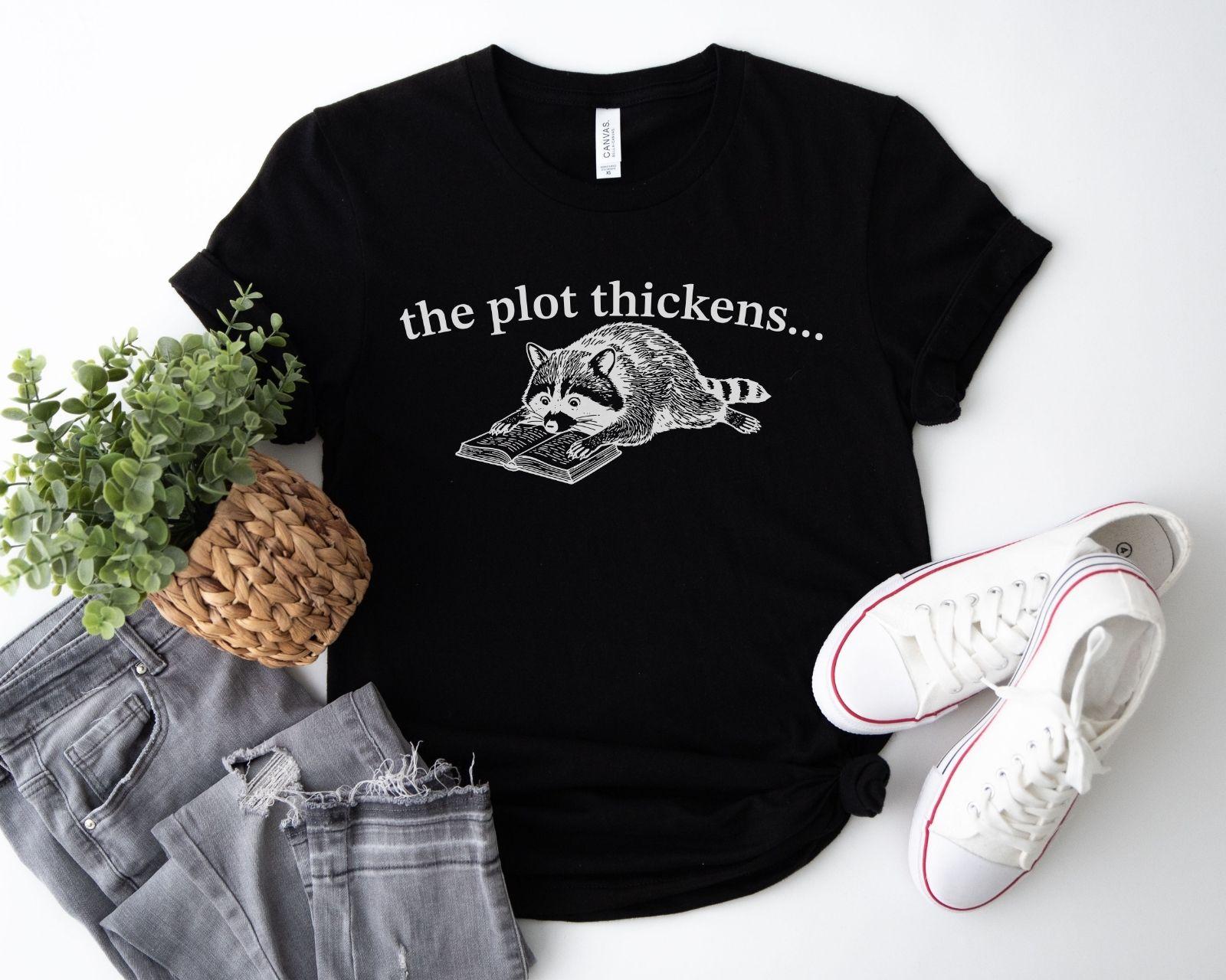 A bella canvas 3001 shirt with the saying "file:///Users/zakaria-bassim-elidrissi/Documents/Etsy/Shopify%20designs/the%20plot%20thickens"