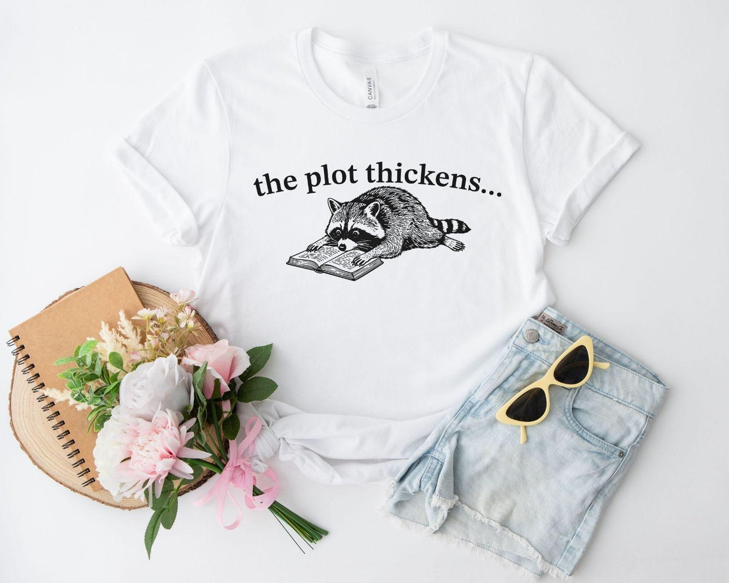 A bella canvas 3001 shirt with the saying "file:///Users/zakaria-bassim-elidrissi/Documents/Etsy/Shopify%20designs/the%20plot%20thickens"
