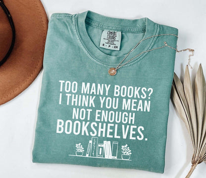 A comfort colors® shirt with the saying "too many books I think you mean not enough bookshelves"