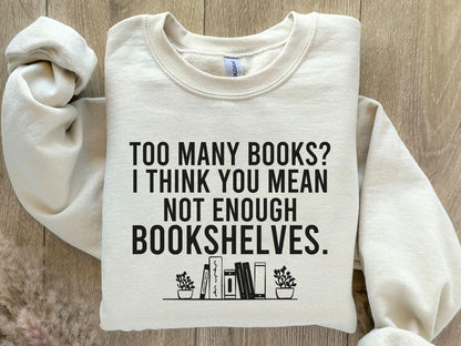 A Gildan 18000 sweatshirt with the saying "too many books I think you mean not enough bookshelves"