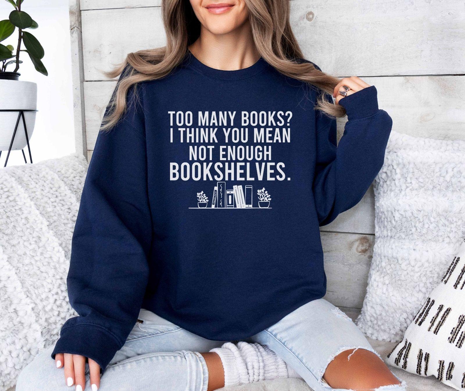 A Gildan 18000 sweatshirt with the saying "too many books I think you mean not enough bookshelves"