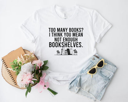 A comfort colors® shirt with the saying "too many books I think you mean not enough bookshelves"