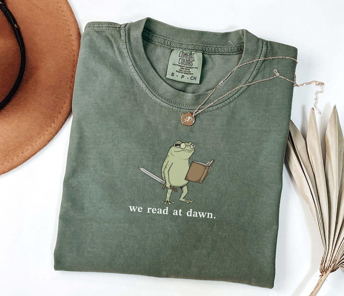 A comfort colors® shirt with the saying "we read at dawn"