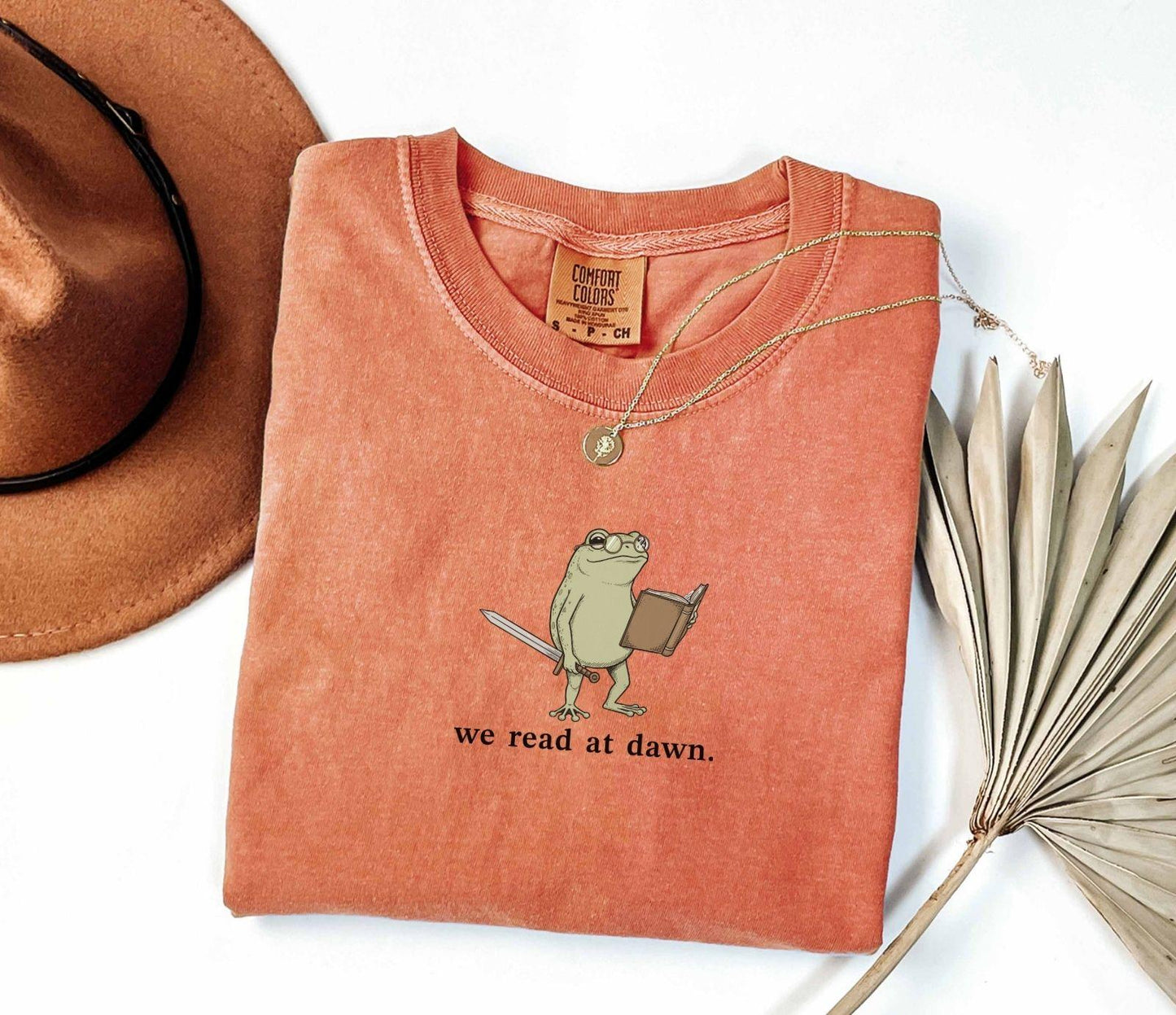 A comfort colors® shirt with the saying "we read at dawn"