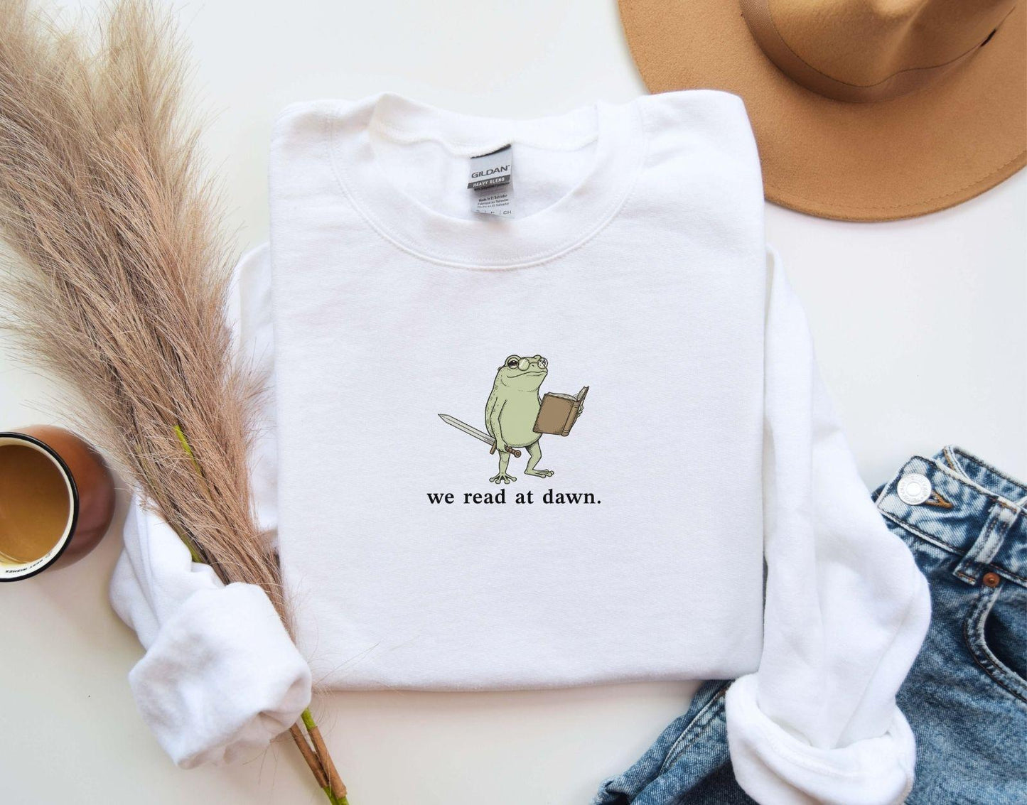 A Gildan 18000 sweatshirt with the saying "we read at dawn"