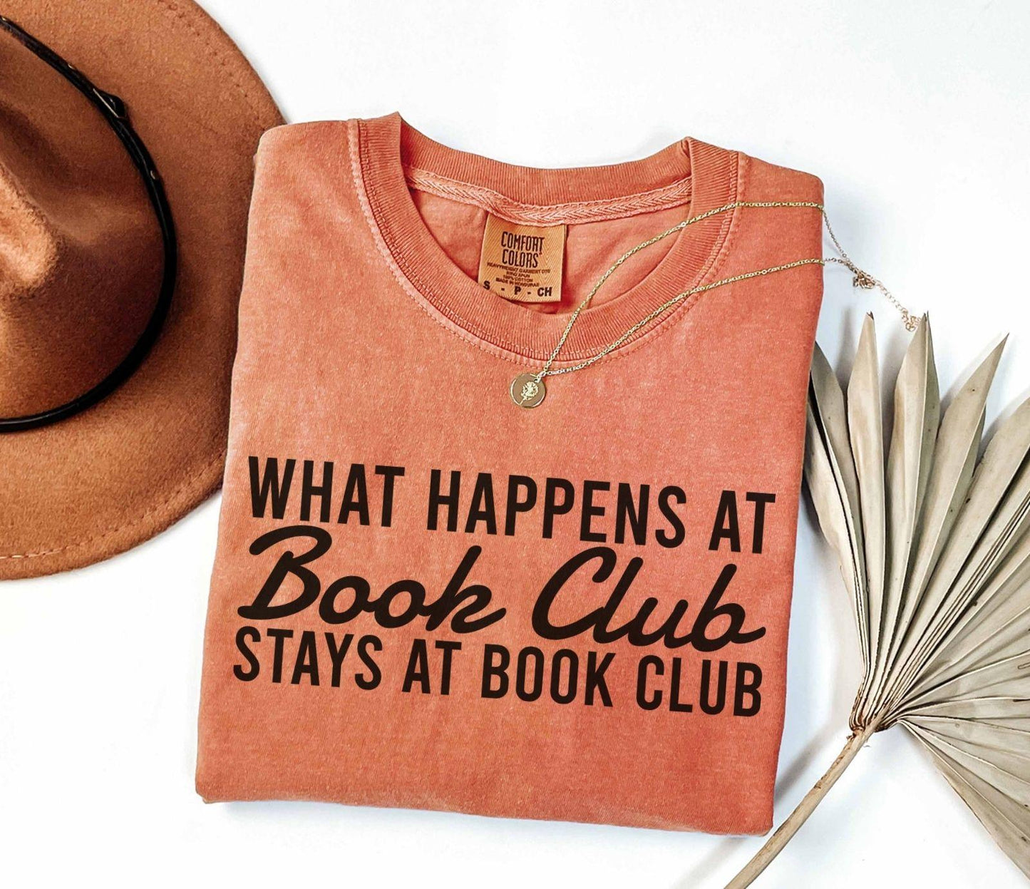 A comfort colors® shirt with the saying "what happens at book club stays at book club"