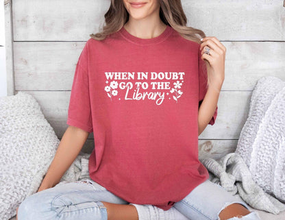 A comfort colors shirt with the saying "When in doubt go to the library"