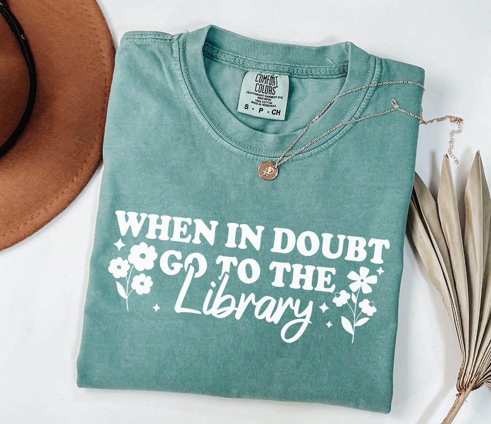 A comfort colors shirt with the saying "When in doubt go to the library"