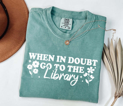 A comfort colors shirt with the saying "When in doubt go to the library"
