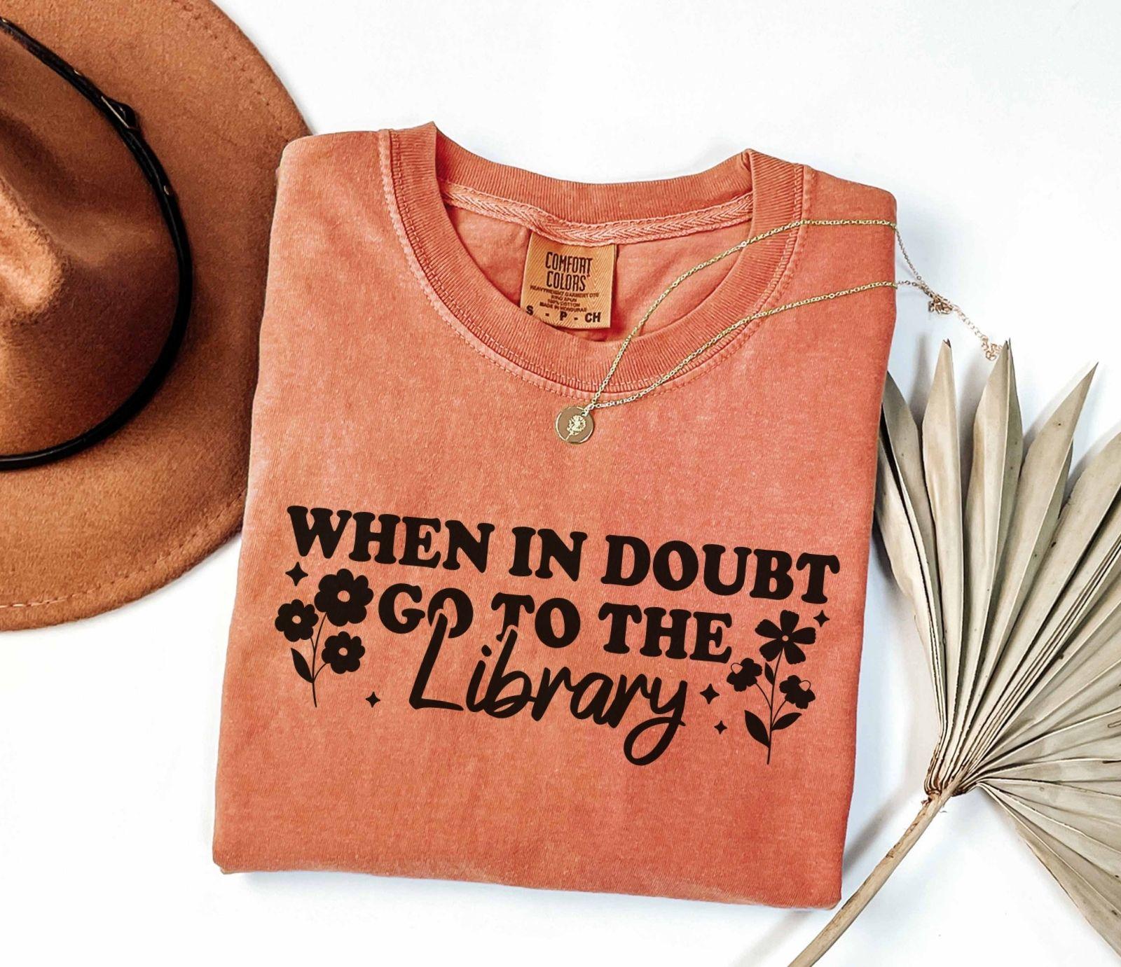 A comfort colors shirt with the saying "When in doubt go to the library"