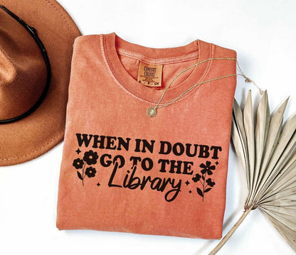 A comfort colors shirt with the saying "When in doubt go to the library"