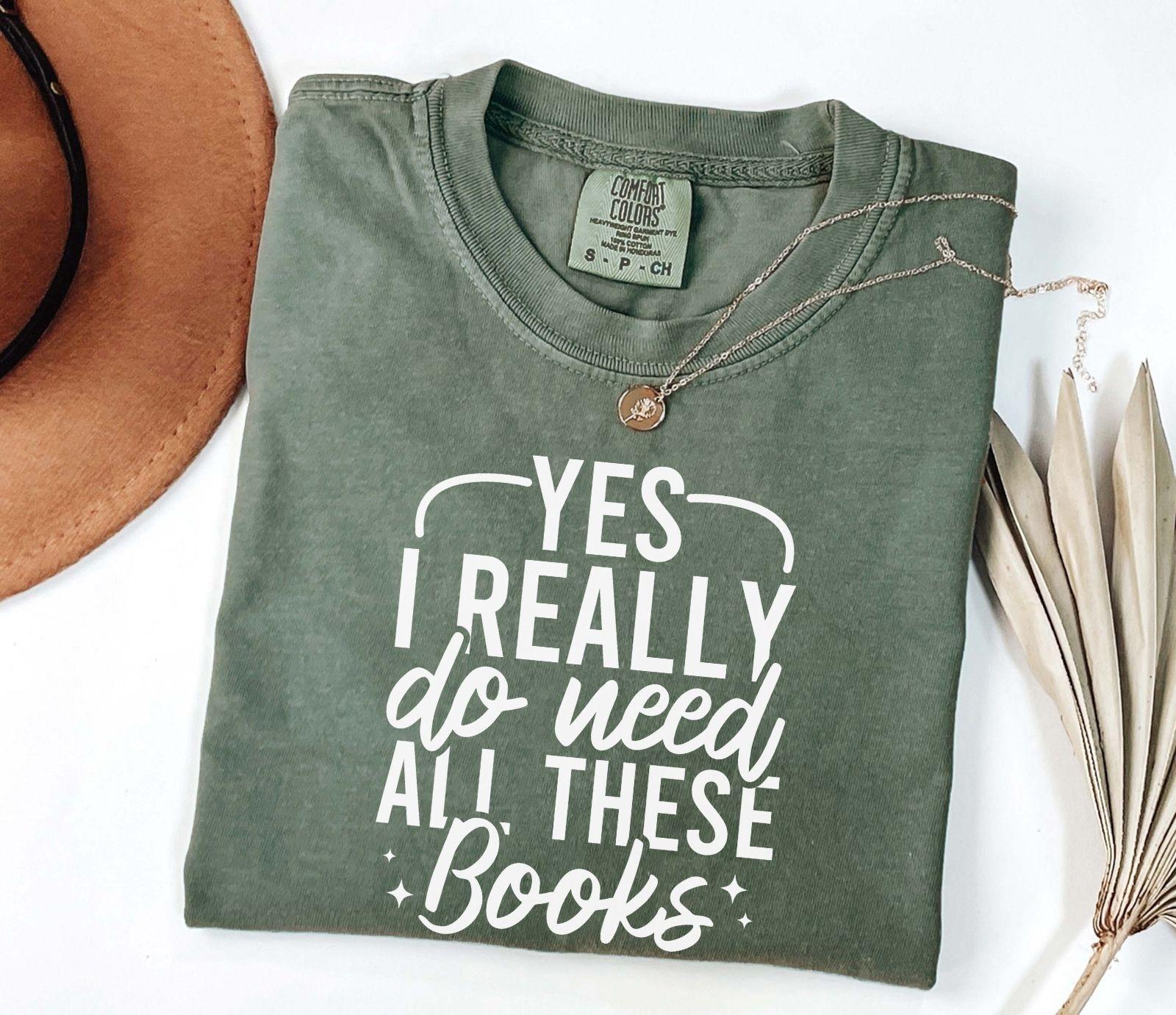 A comfort colors shirt with the saying "Yes I really do need all these books"