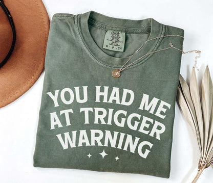 A comfort colors® shirt with the saying "you had me at trigger warning"