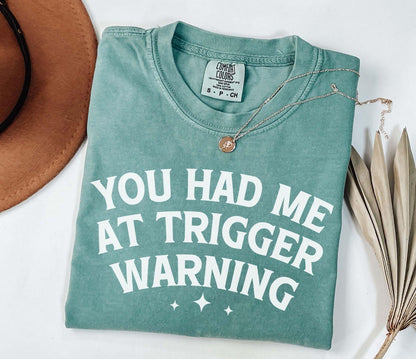 A comfort colors® shirt with the saying "you had me at trigger warning"