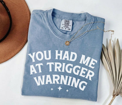 A comfort colors® shirt with the saying "you had me at trigger warning"