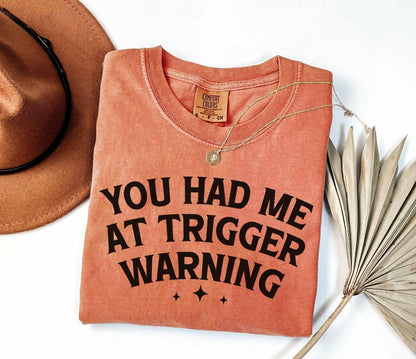 A comfort colors® shirt with the saying "you had me at trigger warning"