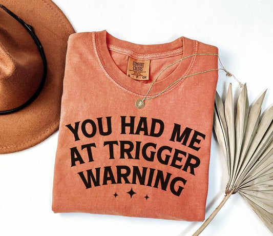 A comfort colors® shirt with the saying "you had me at trigger warning"