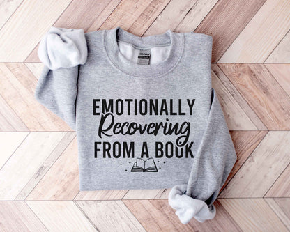 Sport grey sweatshirt with 'Emotionally Recovering from a Book' text on a wooden floor