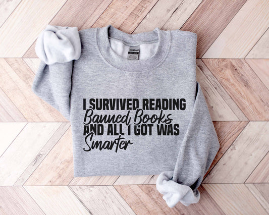 A sport grey color sweatshirt with the saying "I Survived Reading Banned Books And All I Got Was Smarter"