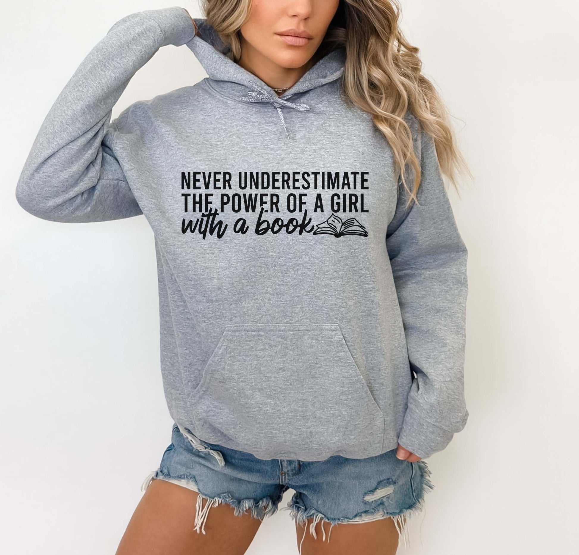 Person wearing a sport grey color hoodie with text and denim shorts on a white background
